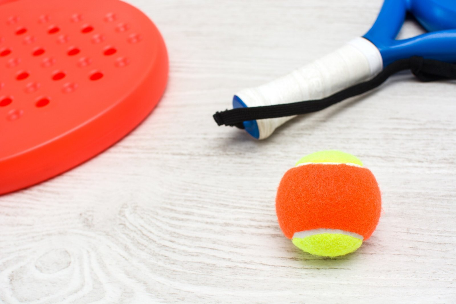 Raquetas y pelota de pádel dispuestas como apoyo editorial para pequeños regalos deportivos