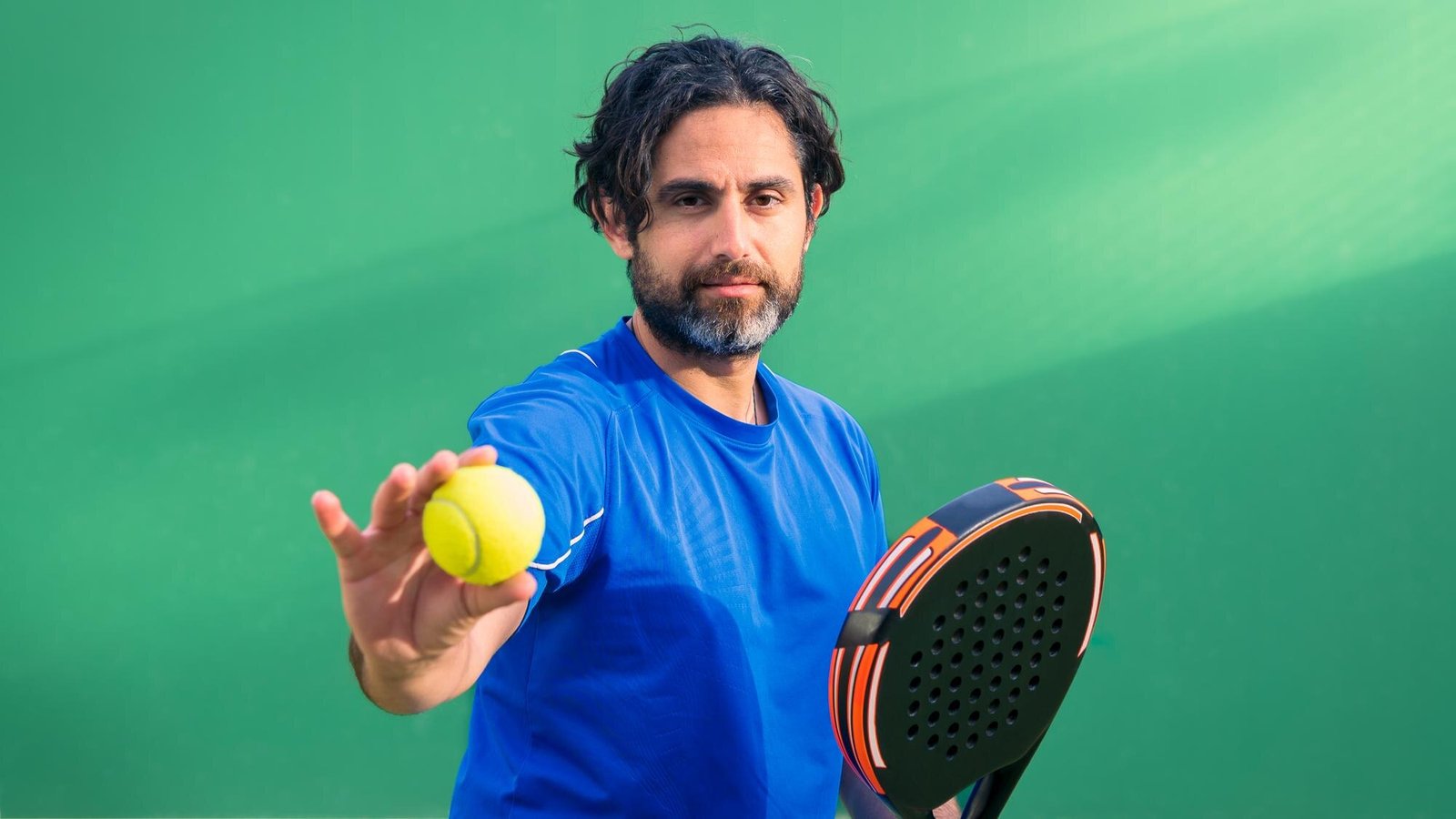 Monitor de pádel sosteniendo una pelota y una pala