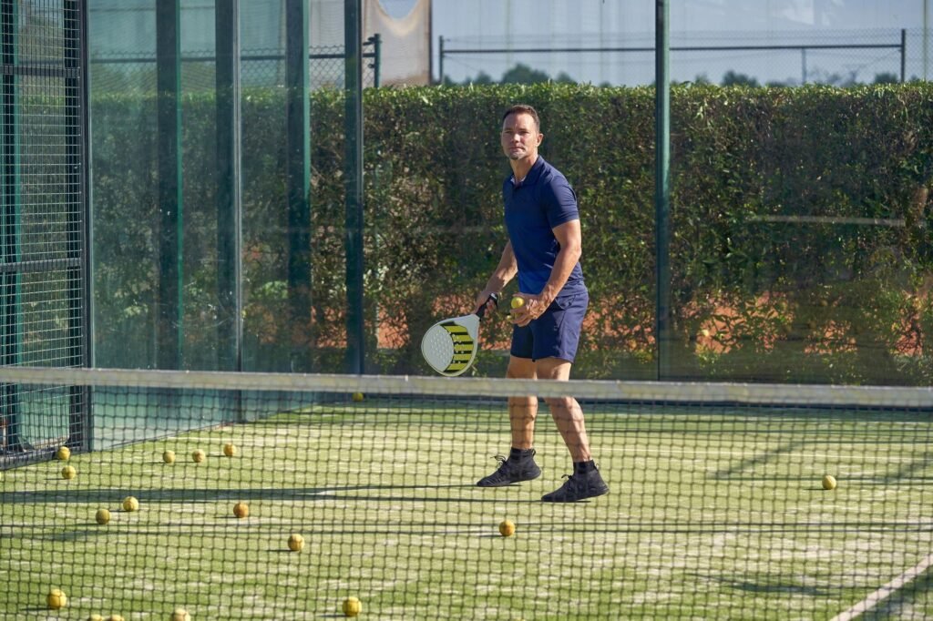 Jugador de pádel entrenando en una pista con su pala