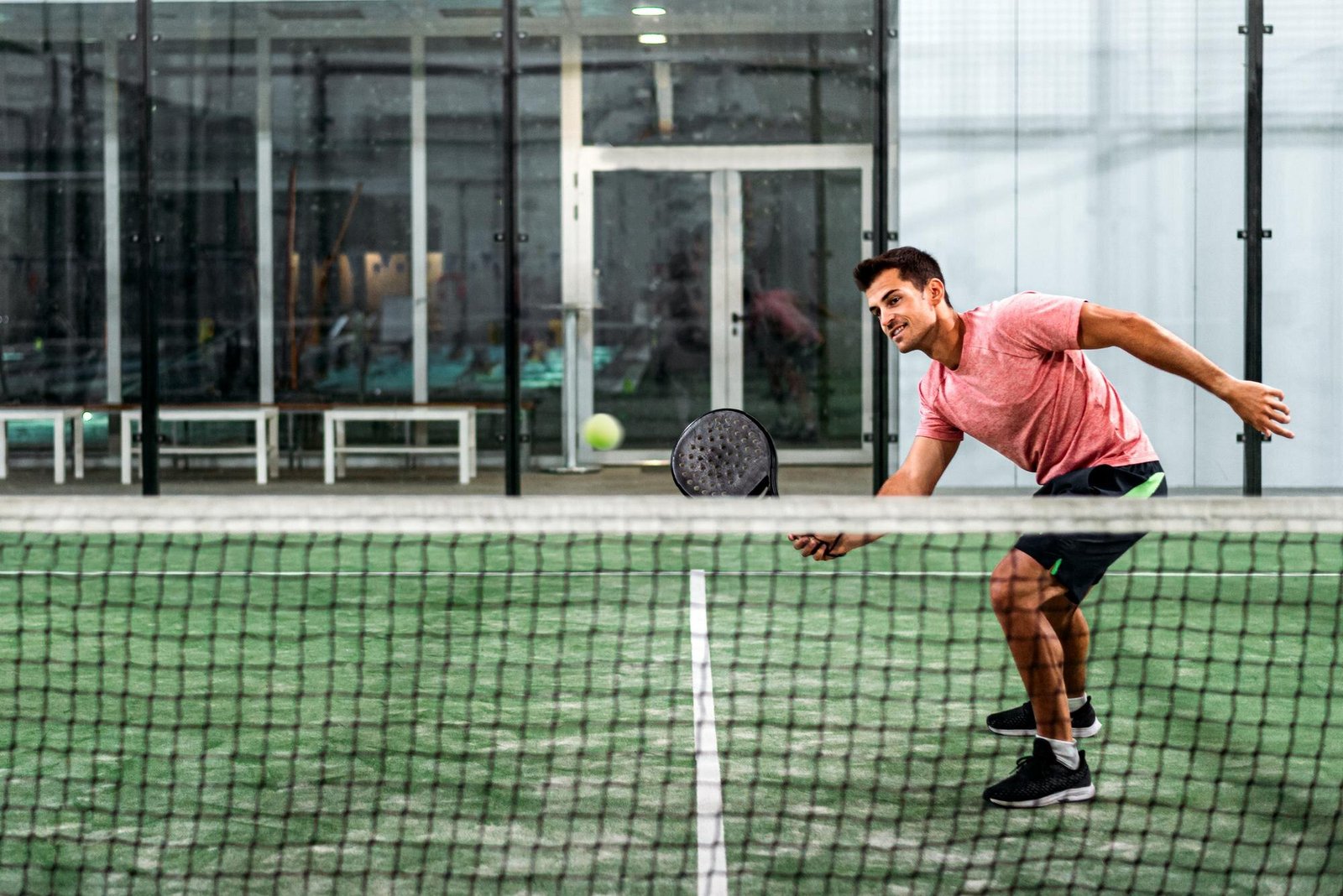 Jugador de pádel en una pista con pala perforada